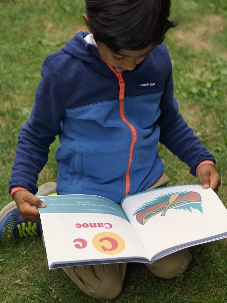 Kedaar reading his book in the grass