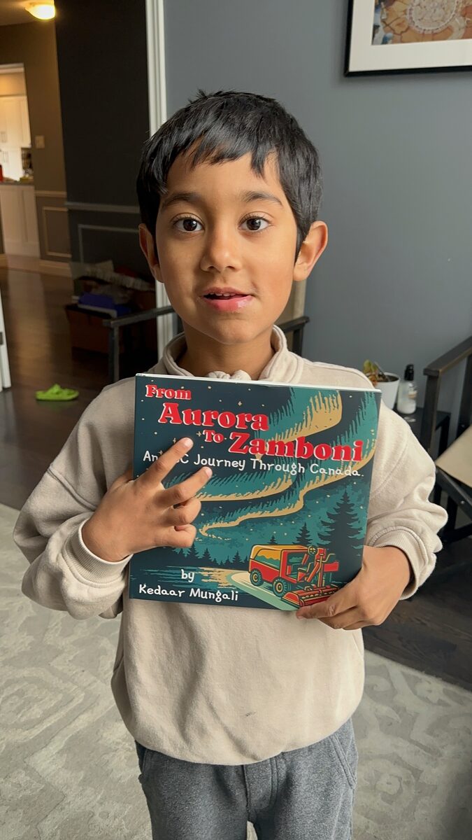 Kedaar holding his book From Aurora to Zamboni